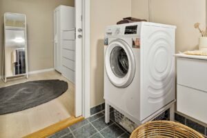 Waschmaschinenfuß mit aufgesetztem Gummidämpfer auf Fliesenboden