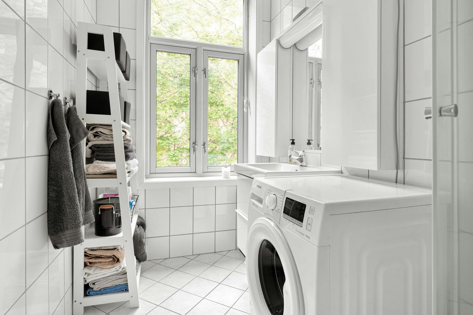 Waschmaschine auf hellem Fliesenboden in einem Badezimmer